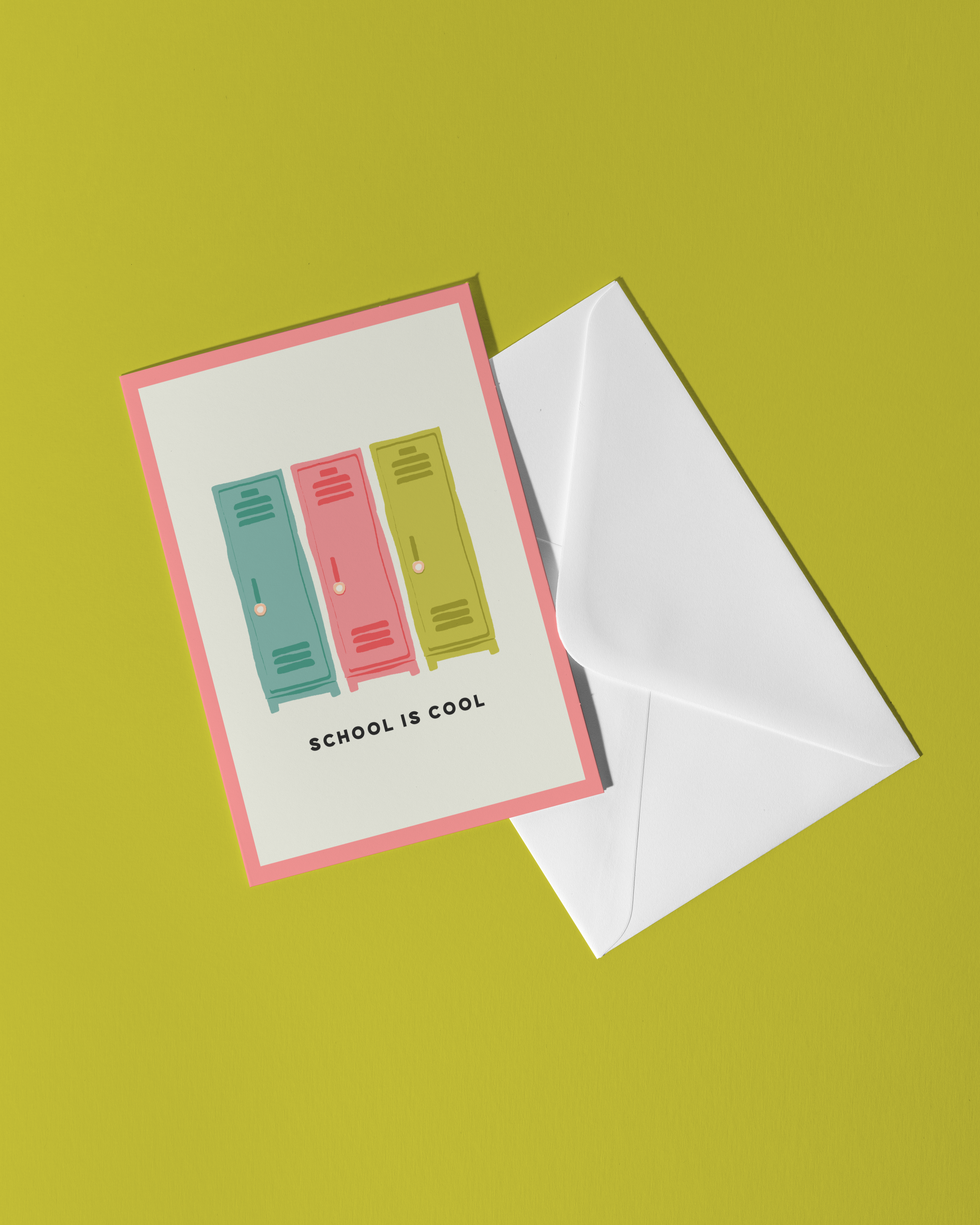 Greeting card with 'School is Cool' text and two colorful lock designs, accompanied by a white envelope on a green background.